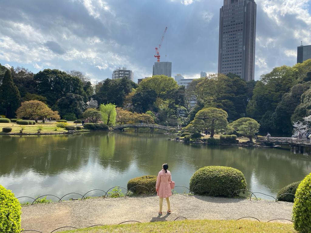 A woman dressed in pink looking upon a city landscape